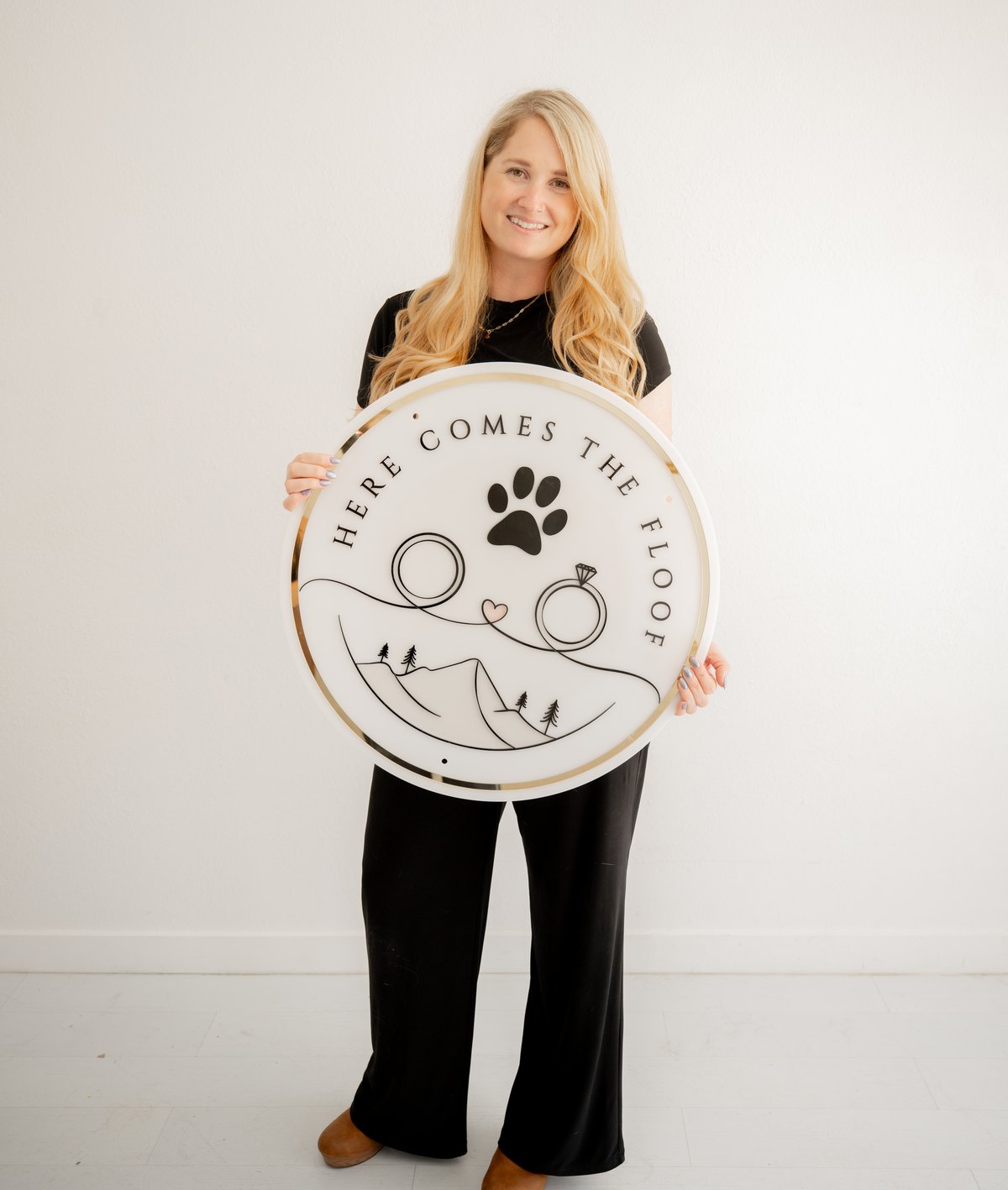 Megan Logsdon holding the Here Comes the Floof sign