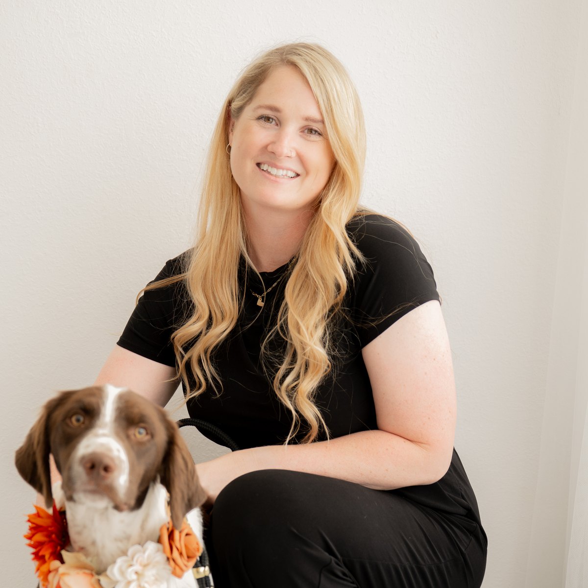 Megan Logsdon, founder of Here Comes the Floof, with a dog in a floral wedding collar